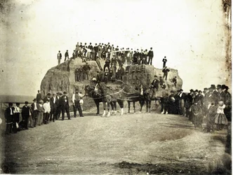 A Crowd of Men, Children, and a Few Horses, Stand on Top of and in Front of the Big Mound Which is Shown Partially Graded